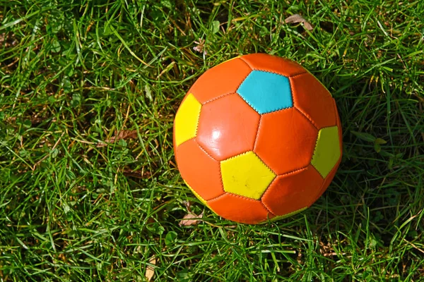 Feche Uma Bola Futebol Infantil Laranja Multicolor Grama Verde Prado — Fotografia de Stock