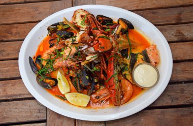 Ahşap masadaki büyük ızgara deniz ürünleri tabağını kapat, yüksek açılı görüş.