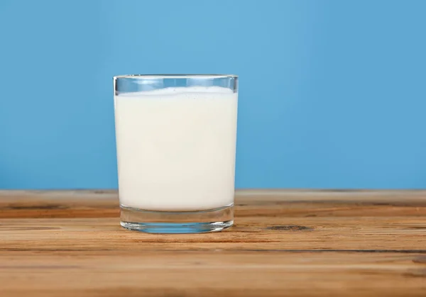 Stäng Ett Glas Full Färsk Mjölk Träbord Över Blå Bakgrund — Stockfoto