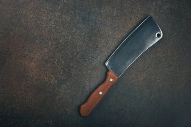 Bir kasap metal et satırını, ahşap saplı, mutfak masası yüzeyinde, üst manzaralı, tam üstte.