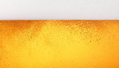 Buzlu bardaktaki köpüklü lager birasının arka plan dokusunu kapatın. Düşük açılı, kenarlı, köpüklü.
