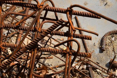 Rusty aşınmış lekeli metal parçalar: Tel, montaj, aksesuar armatür kirli bir beton zemin