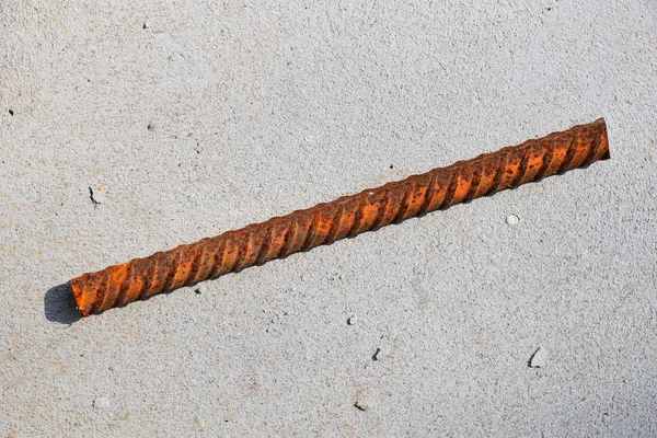 Vágott darab korrodált festett rozsdás fém armatúra felszerelése a bugyborékolt beton padló — Stock Fotó