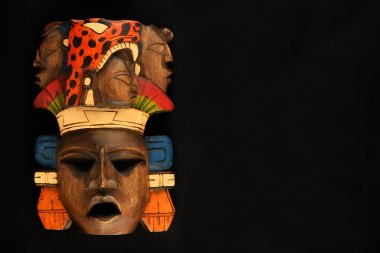 Indian Mayan Aztec wooden carved painted mask isolated on black clipart