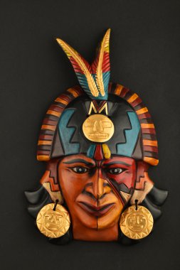 Indian Mayan Aztec ceramic mask with feather isolated on black clipart