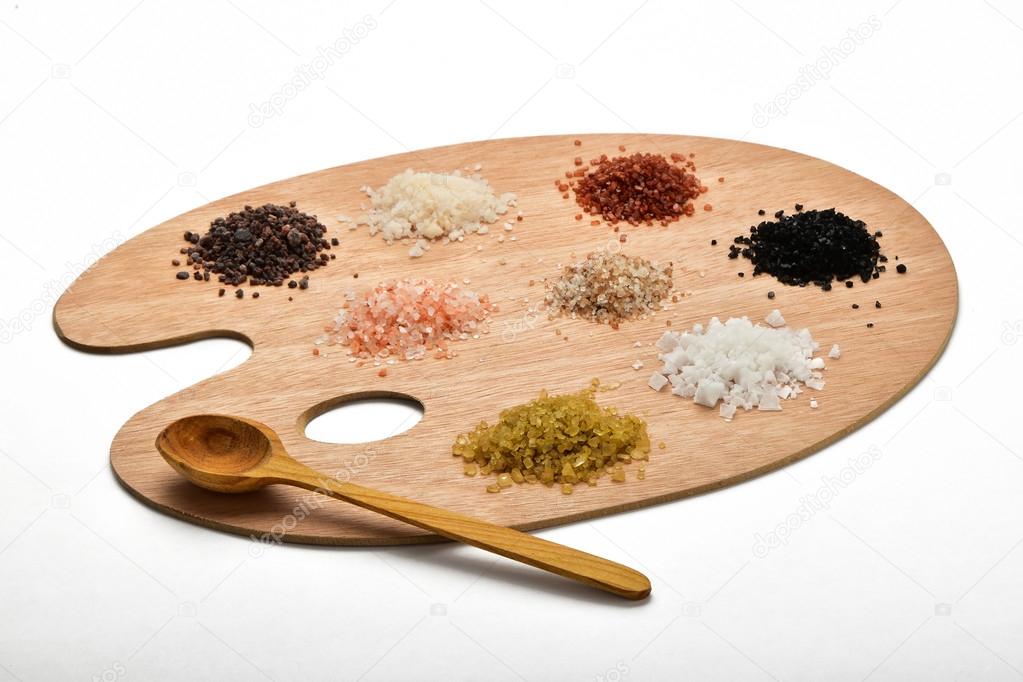 Collection of various salts on wooden palette isolated on white