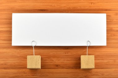 One paper note with two holders isolated on wooden background