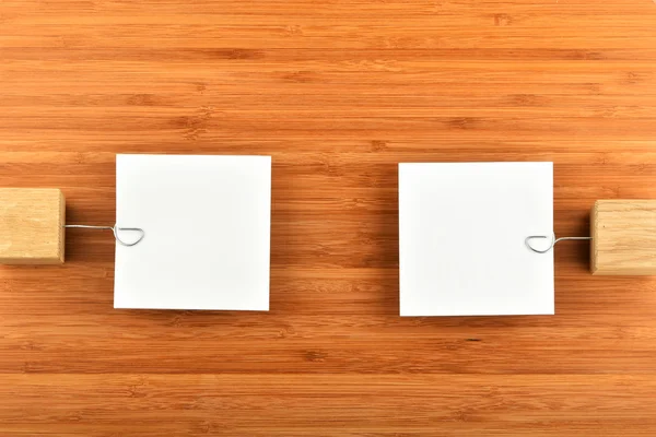 Two paper notes with holders in different directions on wood — 스톡 사진