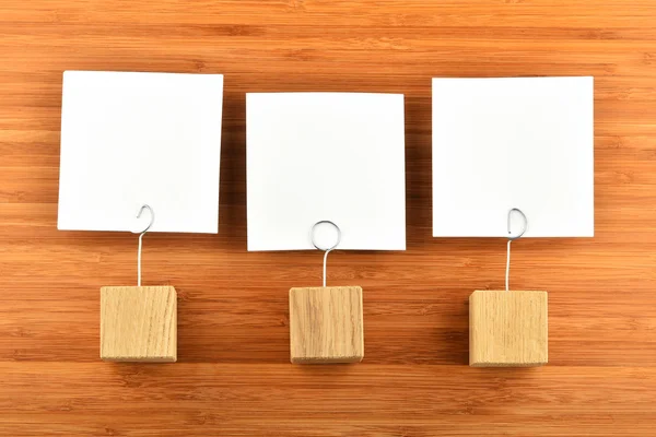Tres notas de papel con soportes sobre fondo de madera — Foto de Stock