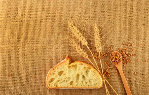 Canvas with wheat ears, bread and ripe grains — Stock Photo, Image