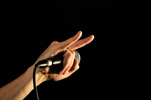 Hand with microphone and devil horns isolated on black — Stock Photo, Image