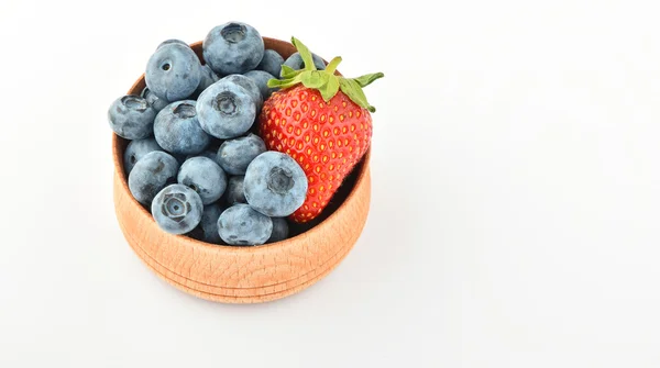 Blaubeeren und eine Erdbeere in Holzschale isoliert auf weiß — Stockfoto
