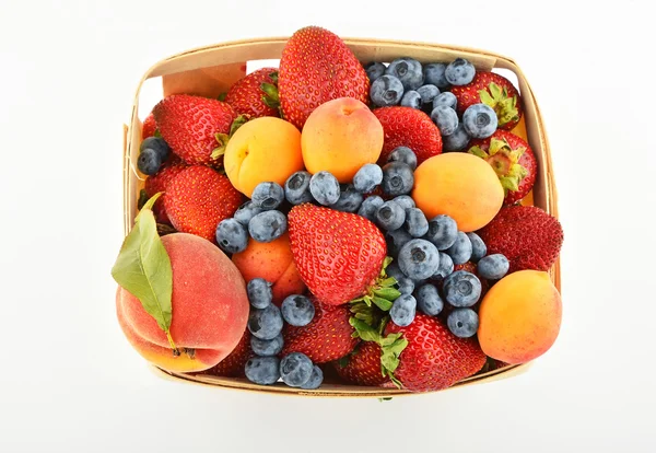 Fraises, abricots, bleuets, pêches dans le panier isolé sur — Photo