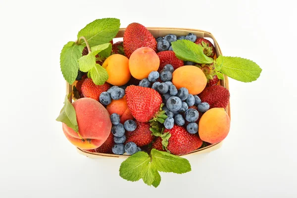 Strawberries, apricots, blueberries, peach in basket isolated on — Stock Photo, Image