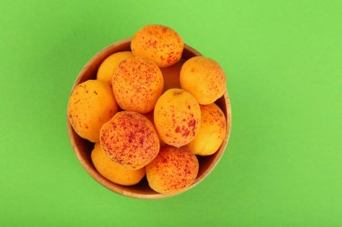 Yeşil arka plan üzerinde büyük ahşap kase taze olgun kayısı kapatın, yüksek üst görünümü, doğrudan yukarıda