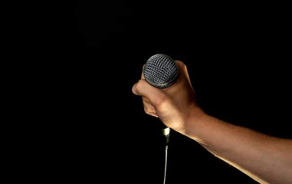 Mano maschile con microfono isolato su nero — Foto Stock