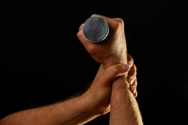 Two male hands with microphone isolated on black — Stock Photo, Image