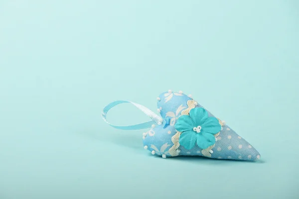 Un corazón textil con flor sobre fondo azul — Foto de Stock