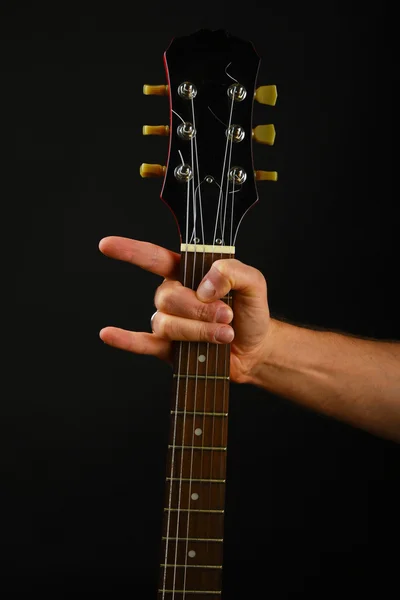 Hand with guitar and devil horns isolated on black — Stok fotoğraf