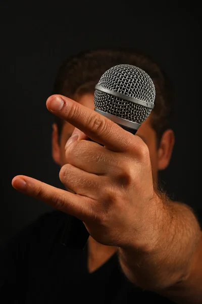 Hand with microphone and devil horns isolated on black — Stock Photo, Image