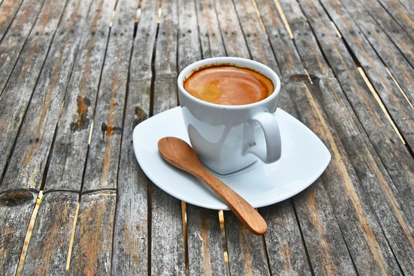 Une tasse pleine de café expresso sur une table en bambou — Photo