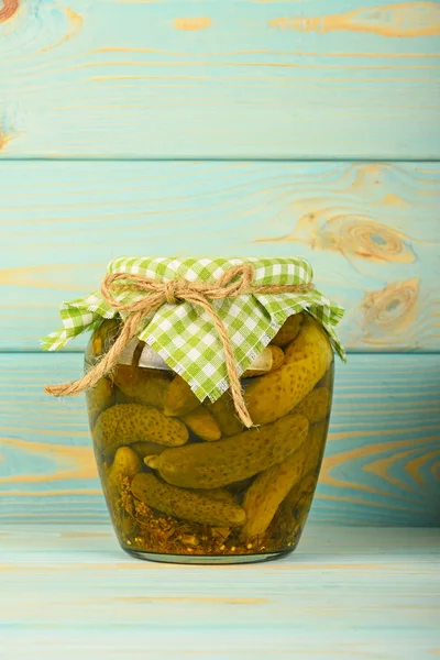 Vaso di cetrioli in salamoia alla superficie di legno vintage blu — Foto Stock