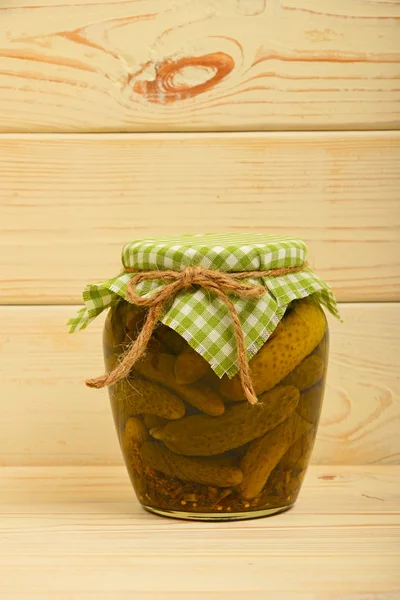 Jar of pickled cucumbers at vintage wood surface — Stock Photo, Image