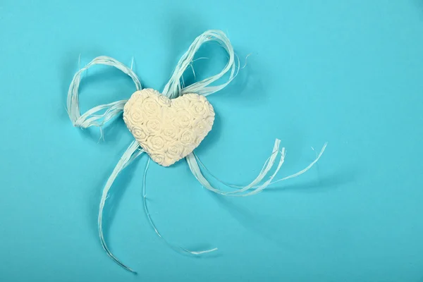 Coração de gesso com flores e fita em fundo azul — Fotografia de Stock