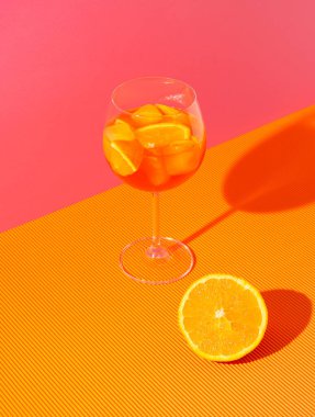 Buzlu kokteyl ve pembe ve turuncu arka planda taze meyve karışımı. Yaz ferahlatıcı içecek konsepti düzenlemesi.