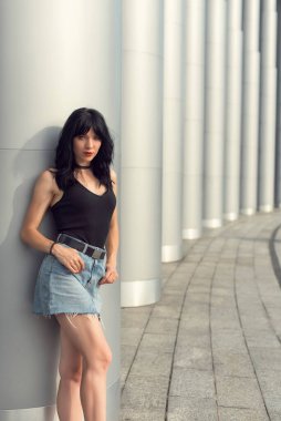 Binaya yakın sütunlu esmer kadın.