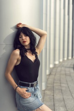 Binaya yakın sütunlu esmer kadın.