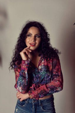 Stüdyoda kıvırcık saçlı genç bir kadın.