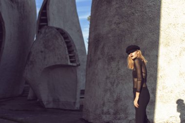 Sarışın, binanın duvarının yanında poz veriyor.