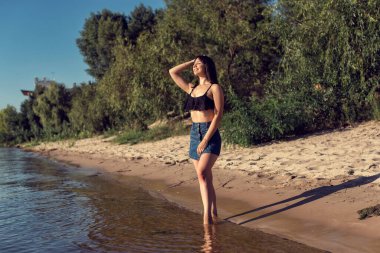 Nehrin kenarındaki kumda bir kız