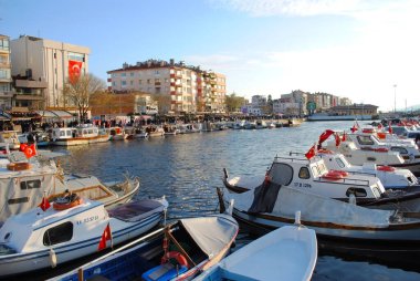 Deniz kenarında yürüyüş yolu. Rıhtımdaki tekneler. Şehir Görünümü.
