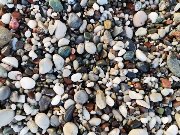 Colored stones. Stones on the beach. Small and big stones on the beach.