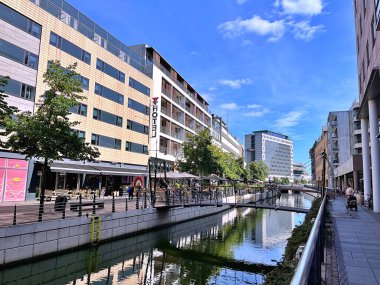 26.08.2025. Aarhus kasabasının şehir merkezindeki Aarhus A nehri boyunca ilerleyin. Mağazalar ve ofisler her iki tarafta, Magasin Alışveriş Merkezi arka planda.