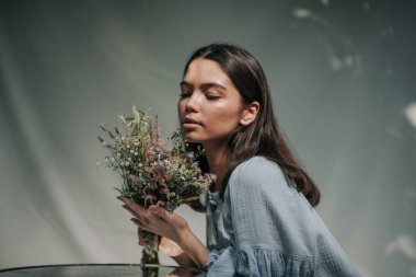 Dışarıda elinde bir buket çiçek tutan neşeli bir kadın. 