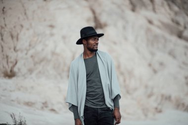  Fötr şapkalı Afro-Amerikan adam granit kanyona karşı poz veriyor. 