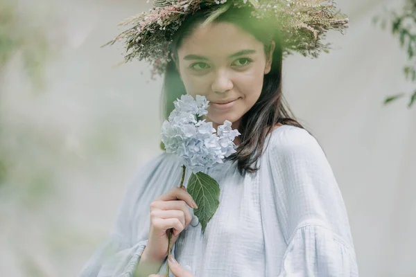 アジサイの花でカメラをポーズする花の花輪の魅力的な女性 — ストック写真