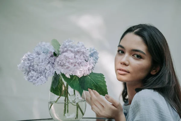 Meisje Aanraken Hortensia Bloemen Vaas Decoratieve Glazen Tafel — Stockfoto