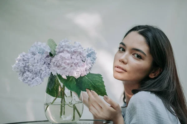 Meisje Aanraken Hortensia Bloemen Vaas Decoratieve Glazen Tafel — Stockfoto