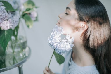 Ortanca çiçekleriyle poz veren güzel kız. 