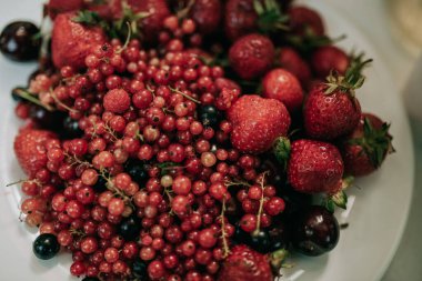 Beyaz arka planda bir kasede taze meyveler.