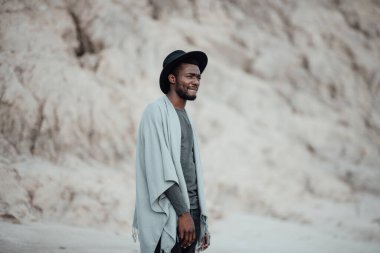  Fötr şapkalı Afro-Amerikan adam granit kanyona karşı poz veriyor. 