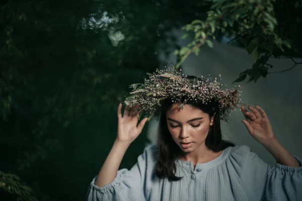 公園でポーズをとっている花の花輪の美しい女性の肖像 — ストック写真