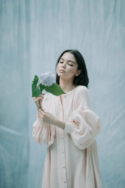 可愛い若い女性がアジサイの花を背景にポーズ — ストック写真
