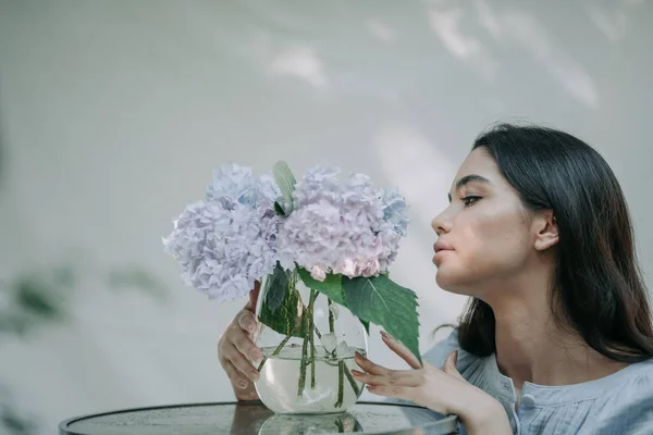 Meisje Aanraken Hortensia Bloemen Vaas Decoratieve Glazen Tafel — Stockfoto