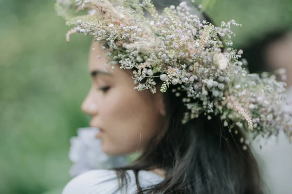 花のリース姿の女性がカメラにポーズをとって — ストック写真