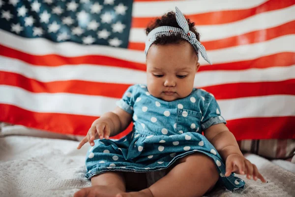 Linda Menina Vestido Azul Sentado Sofá Com Fundo Bandeira Americana — Fotografia de Stock